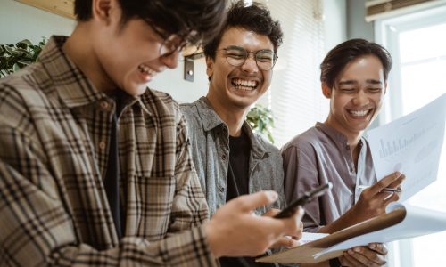 three young asian worker chatting about their product three young asian worker chatting about their product at work