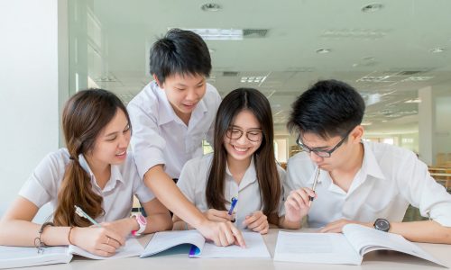Group of asian students in uniform studying together at classroo Group of asian students in uniform studying together at classroom
